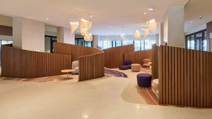 Lobby d’Audessa à Lyon : des alcôves boisées et un mobilier coloré pour un accueil chaleureux. - © ringuetphotographie.fr