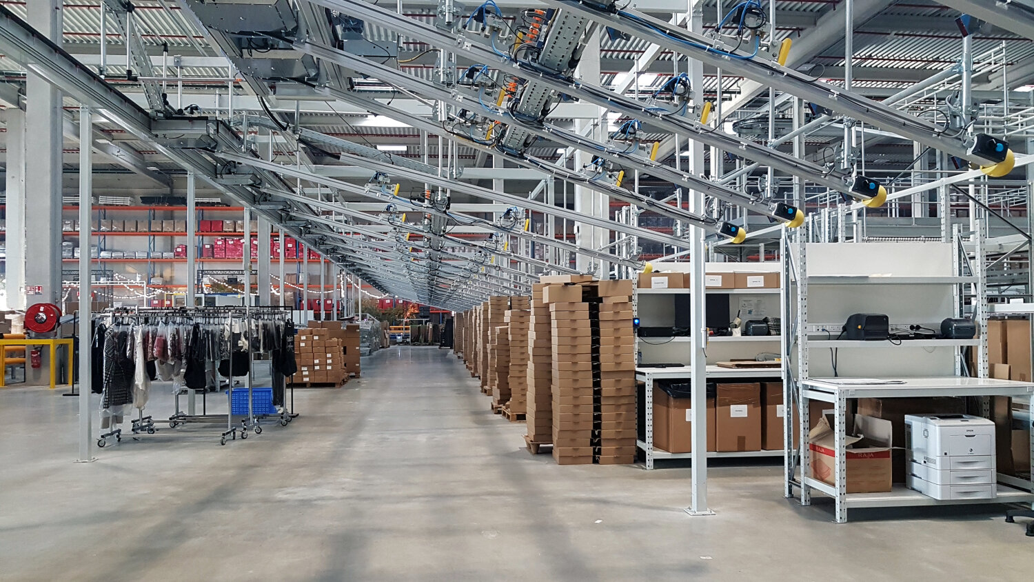 Les produits sont acheminés sur cintre via un convoyeur et ils seront répartis selon les commandes qu’elles soient retail, wholesale ou e-commerce. - © CC / Républik Retail